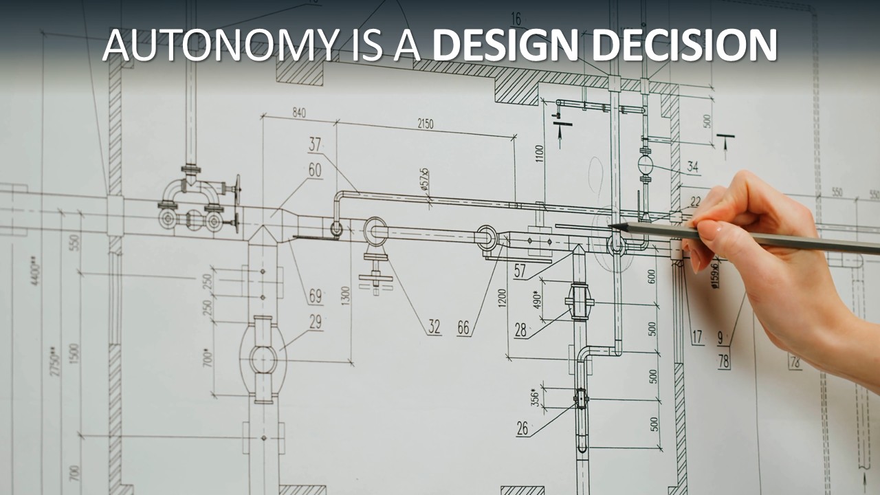 A hand holding a pencil points at a detailed technical engineering blueprint covered in pipework, fittings and dimension measurements. Overlaid text reads: "Autonomy is a design decision."